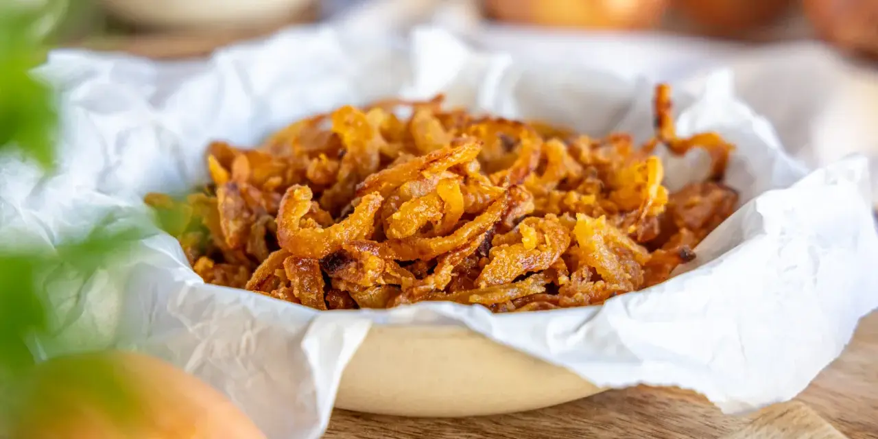 Knusprige frittierte Zwiebelringe in einer Schüssel, bereit zum Genießen.