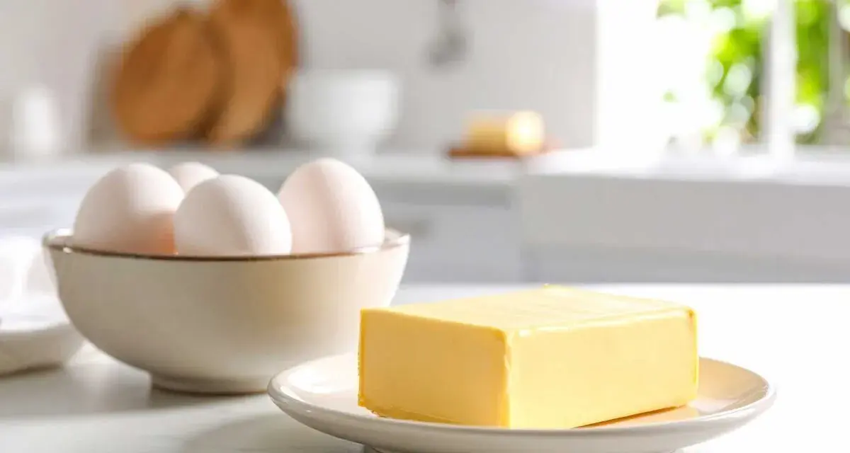 Schüssel mit Eiern und Butter auf einem Teller. Die Frage bei welcher Temperatur stockt Ei wird hier nicht beantwortet.