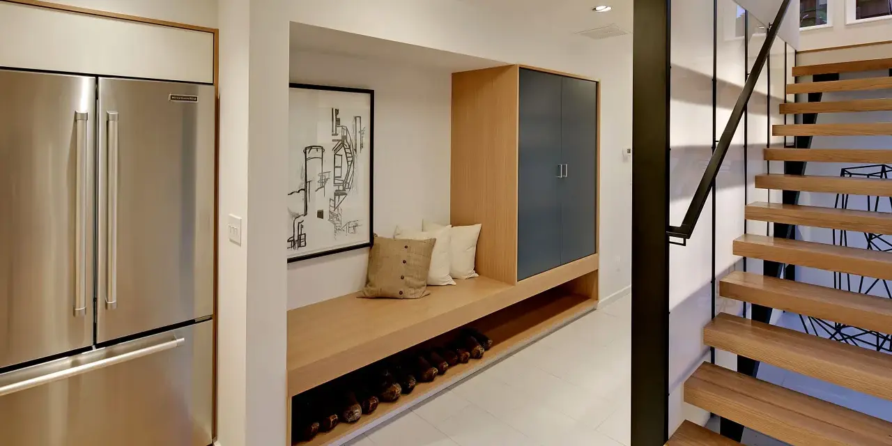 Ideas para decorar un pasillo interior: un banco de madera con almacenamiento, cuadros y una escalera moderna.