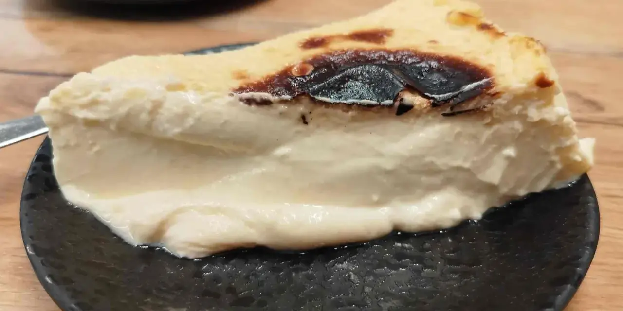 Rebanada cremosa de pastel vasco, con su característico exterior tostado y un interior suave y delicioso.