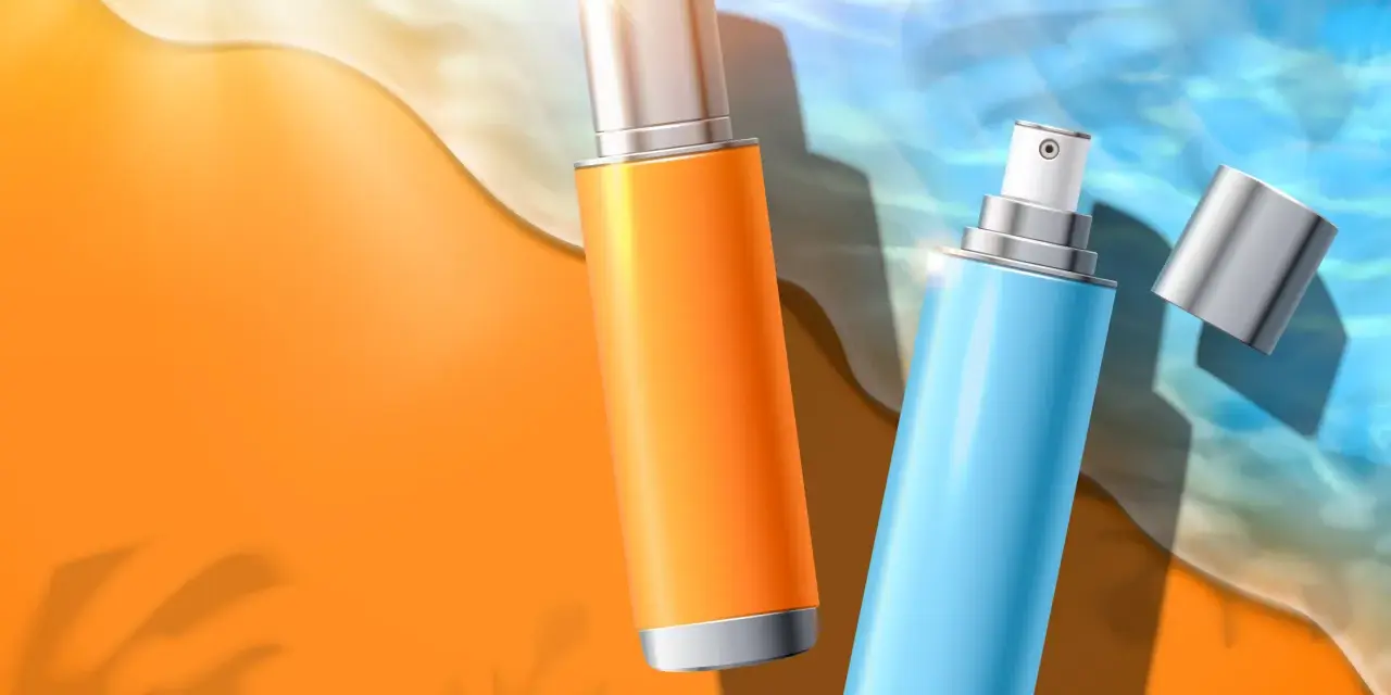 Due flaconi spray, uno arancione e uno azzurro, sulla sabbia dorata con onde marine. Protezione solare con butyl methoxydibenzoylmethane.