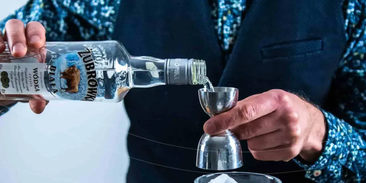 Barman nalewa Żubrówkę do jiggera. Idealna wódka na wesele, by stworzyć niezapomniane drinki.