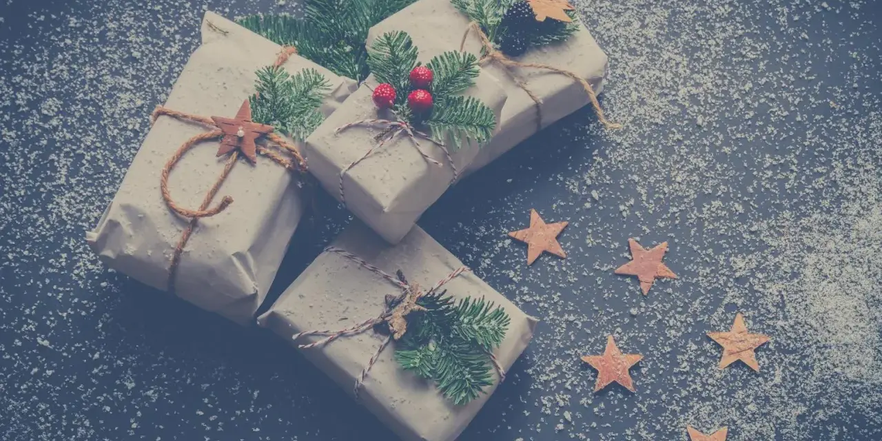 Julklappar inslagna i brunt papper med granris och stjärnor. Perfekta julkort idéer för en mysig julkänsla.