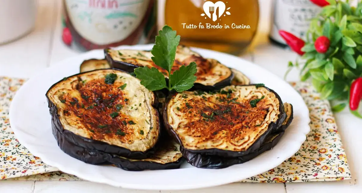 Fette di melanzane in friggitrice ad aria, dorate e profumate, pronte per essere gustate.