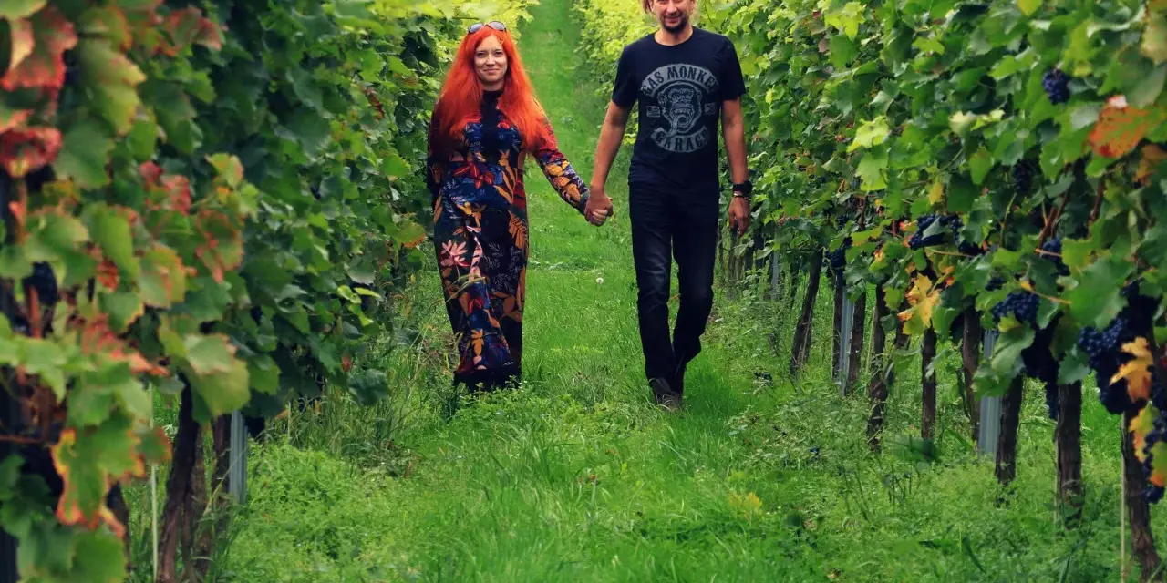 Para spaceruje pośród winnic na Dolnym Śląsku, trzymając się za ręce.