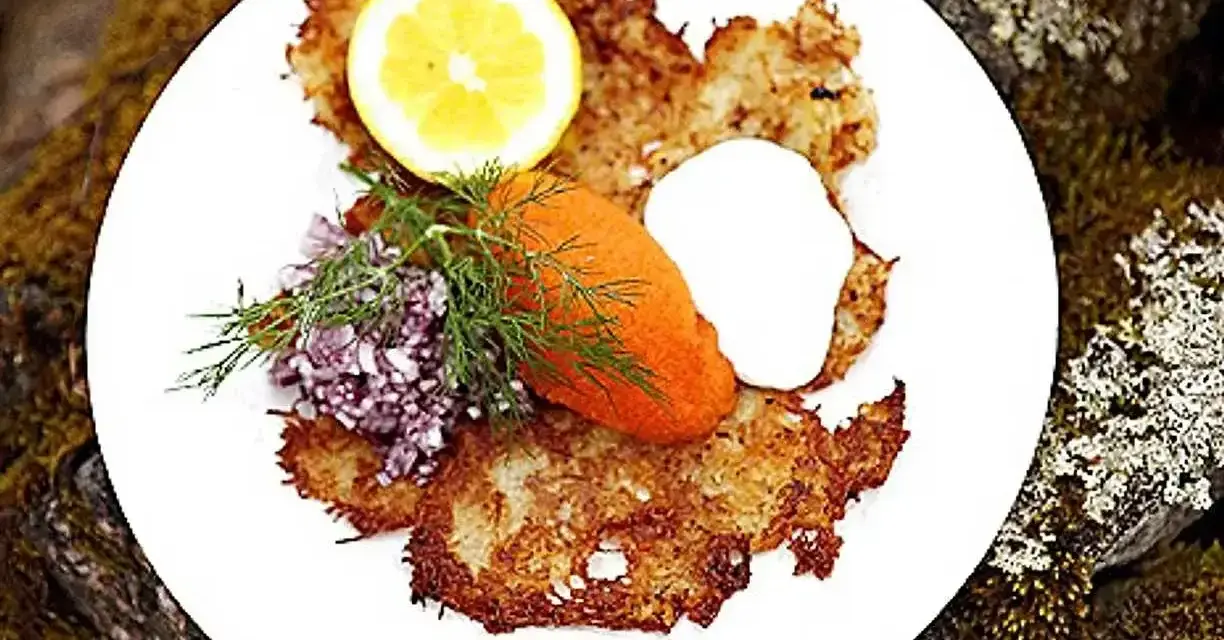En tallrik med krispiga rårakor, serverade med rom, gräddfil, dill, rödlök och citron. Ett härligt råraka recept!