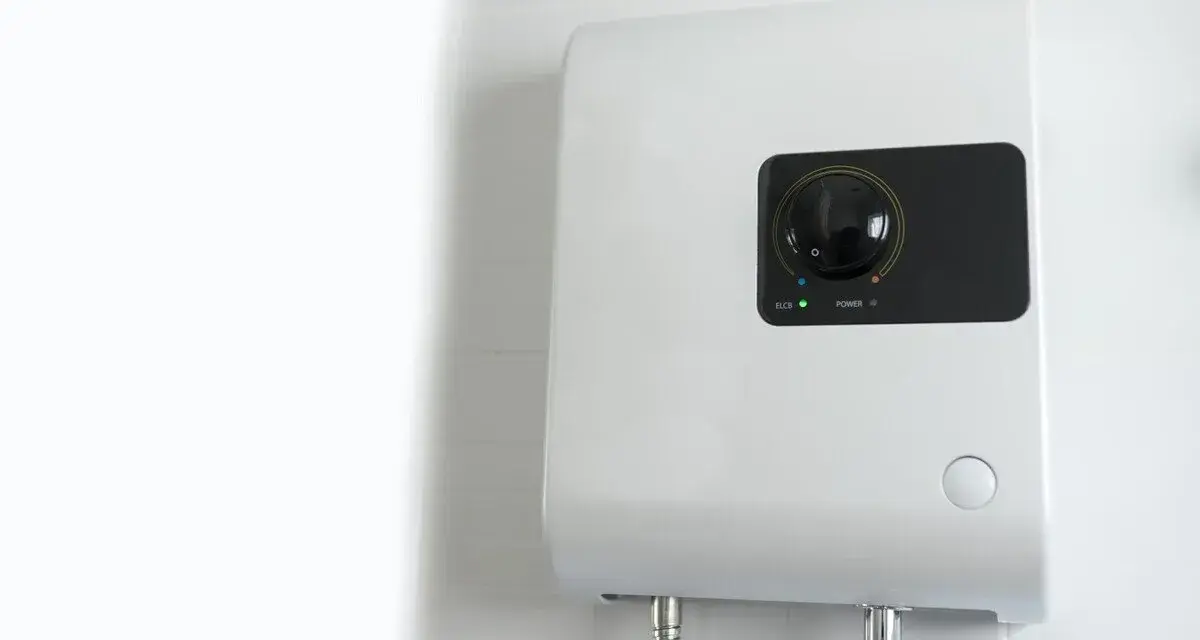 Scaldabagno elettrico istantaneo: pro e contro. Un dispositivo bianco montato a parete con un quadrante nero e indicatori luminosi.