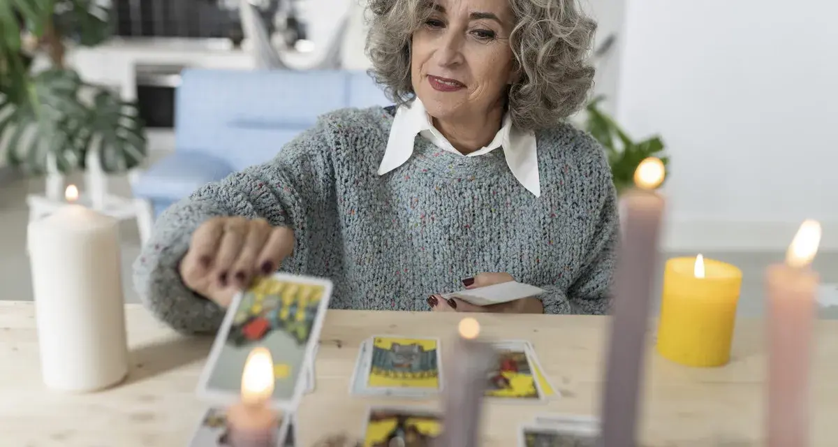 Kobieta z siwymi włosami układa karty tarot, szukając wskazówek dotyczących umiarkowanie uczuć.
