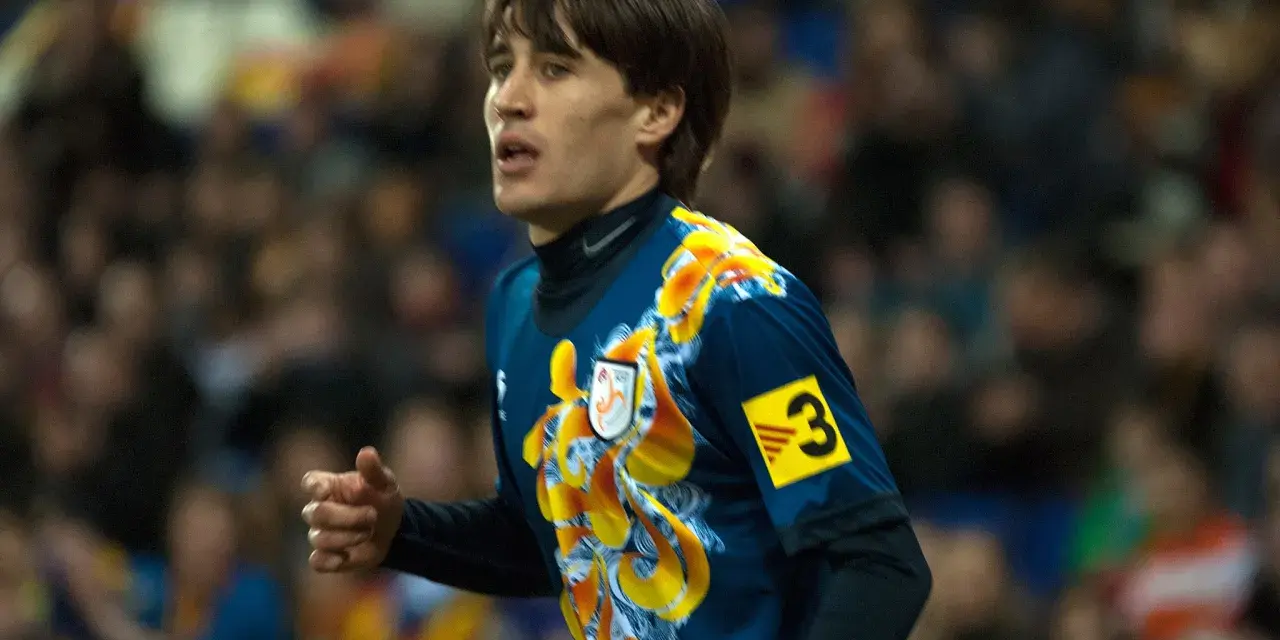Bojan Krkić w akcji, jego bojan krkić statystyki są imponujące. Piłkarz w niebieskiej koszulce z żółtym wzorem.