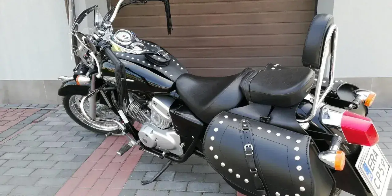 Czarny motocykl Honda Shadow z sakwami i oparciem. Zastanawiasz się, jaki silnik wybrać do tej maszyny?