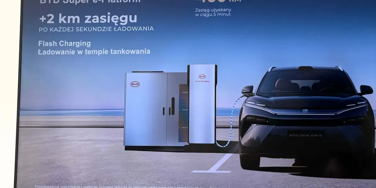 Czarny samochód elektryczny BYD Sealion 8 podłączony do stacji ładowania Flash Charging.
