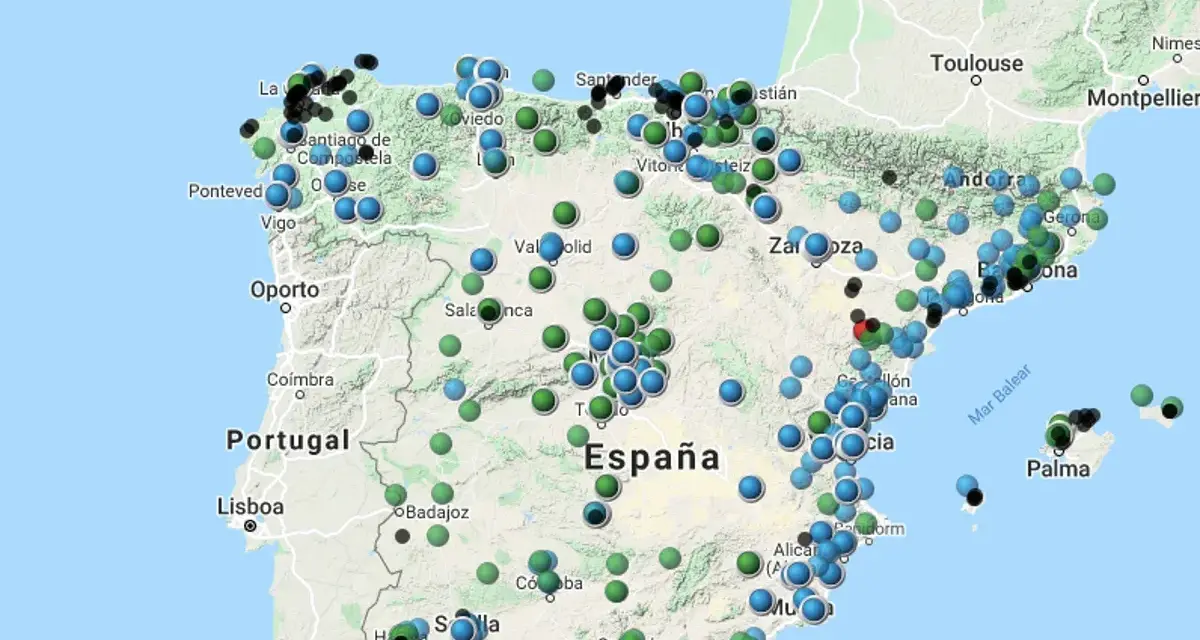 Mapa de España con puntos de colores que indican niveles de contaminacion atmosferica.