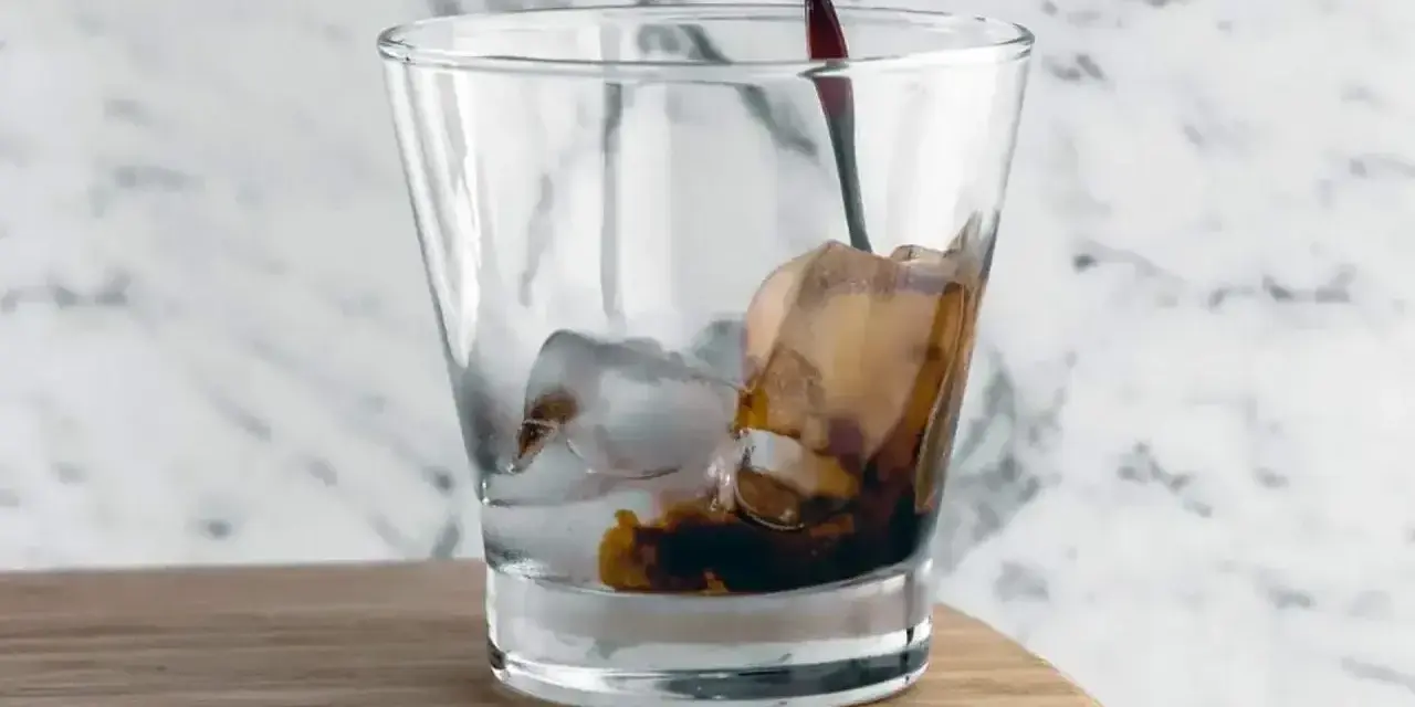 Kall kaffedrink hälls i ett glas med is.