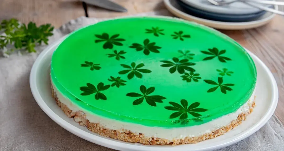 Grüne Philadelphia Torte mit Waldmeister-Gelee und zarten Blüten. Ein erfrischender Genuss!