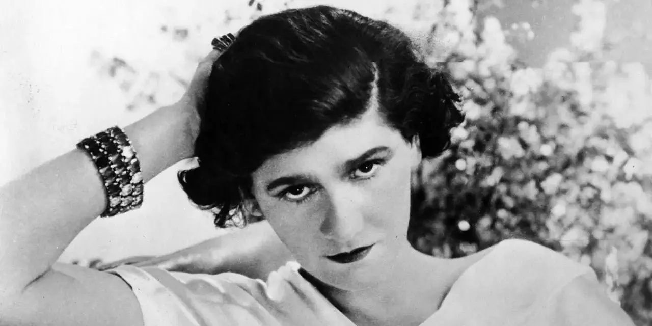 Coco Chanel negli anni '20, con un bracciale scintillante e un'espressione enigmatica.