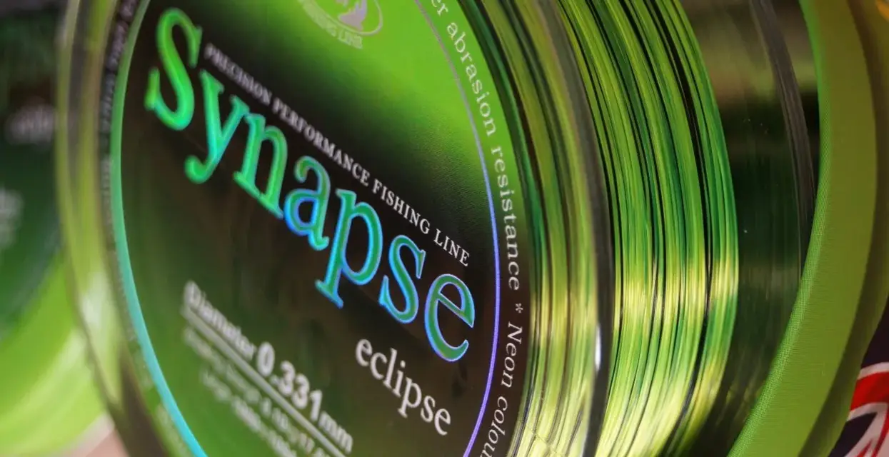 Jaka żyłka karpiowa do dalekich rzutów? Zielona żyłka Synapse Eclipse, 0.331mm, z napisem "Super abrasion resistance", idealna na długie dystanse.