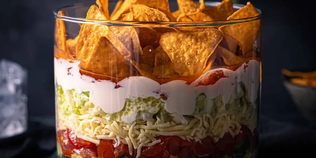 Schichtsalat im Glas mit Nachos: Gurken, Bohnen, Tomaten, Käse, Salat, Sauerrahm und Salsa. Ein bunter Nacho Salat, der Lust auf mehr macht.