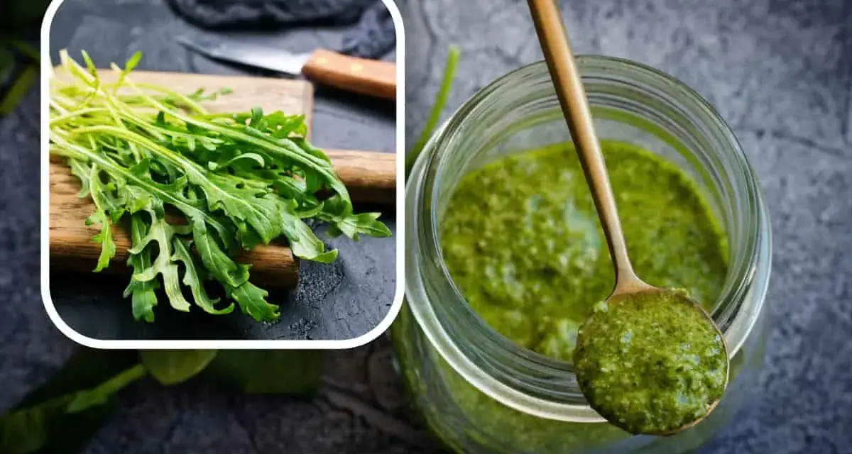Un mazzetto di rucola fresca su un tagliere e un barattolo pieno di vibrante pesto di rucola, pronto per insaporire i tuoi piatti.