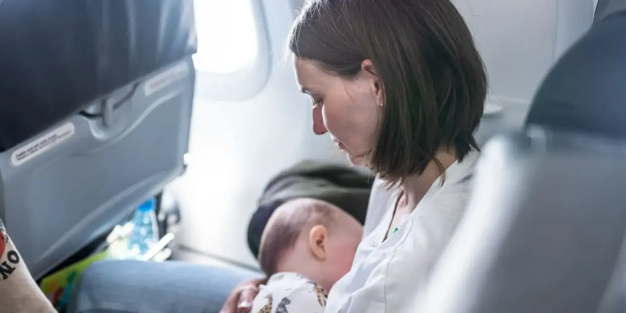 Mamma allatta il suo neonato di 6 mesi in aereo, un momento intimo durante il viaggio.