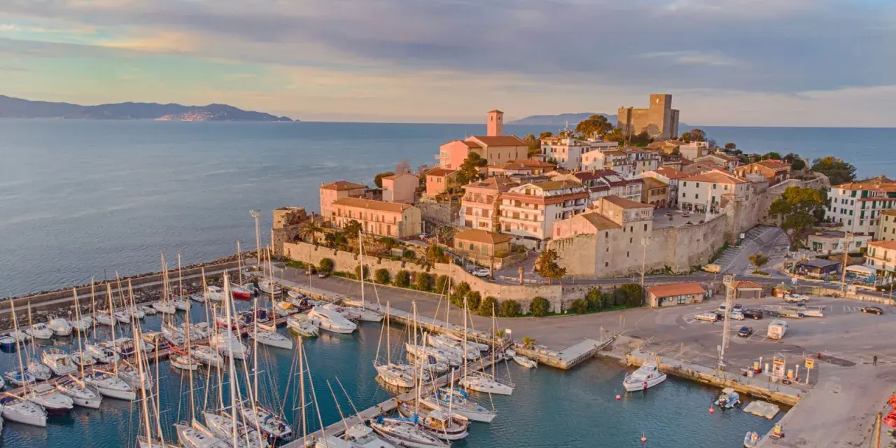 Porto con borgo medievale e castello, ideale per scoprire cosa visitare in Maremma in 3 giorni.