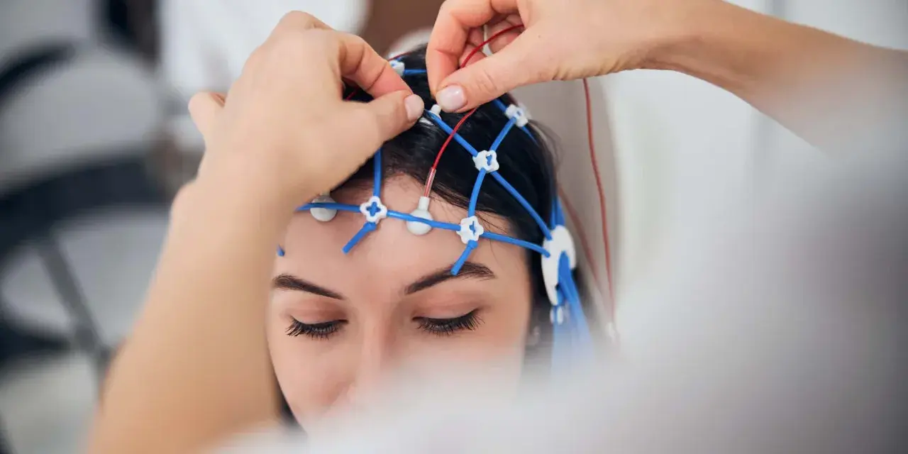 Eine Person erhält eine EEG-Untersuchung. Elektroden werden auf dem Kopf platziert, um die Gehirnaktivität zu messen.