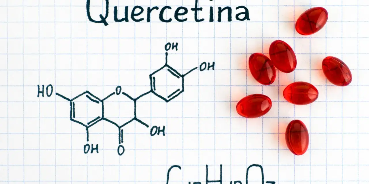 Fórmula química de la quercetina, un flavonoide con propiedades antioxidantes, junto a cápsulas rojas.