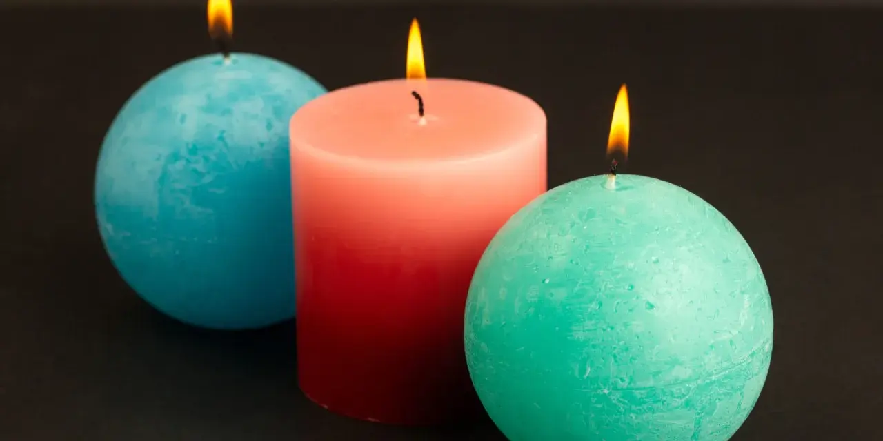 Trzy świece: dwie okrągłe, turkusowe i jedna walcowata, łososiowa. Płonące, tworzą ciepłą atmosferę. Pomarańczowa świeca znaczenie to radość i energia.