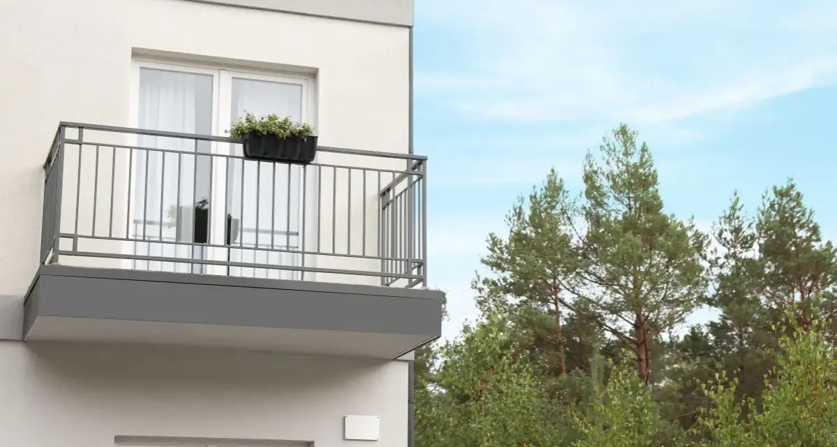 Nowy balkon z kwiatami, z którego roztacza się widok na las. Czy to miejsce wolne od podatku od balkonu?