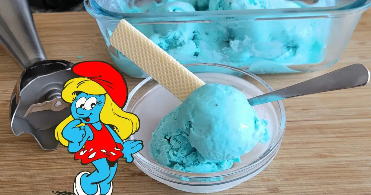 Schlumpfine genießt engelblaues Eis. Ein Handmixer und ein Waffelblatt liegen daneben.