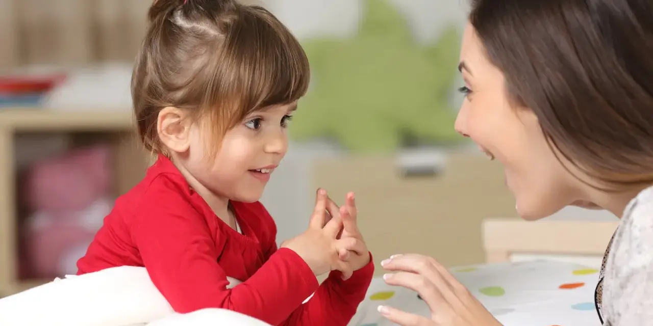 Ein kleines Mädchen und eine Frau sprechen liebevoll miteinander. Ein Moment der psychosexuellen Entwicklung, der Geborgenheit und Vertrauen schafft.