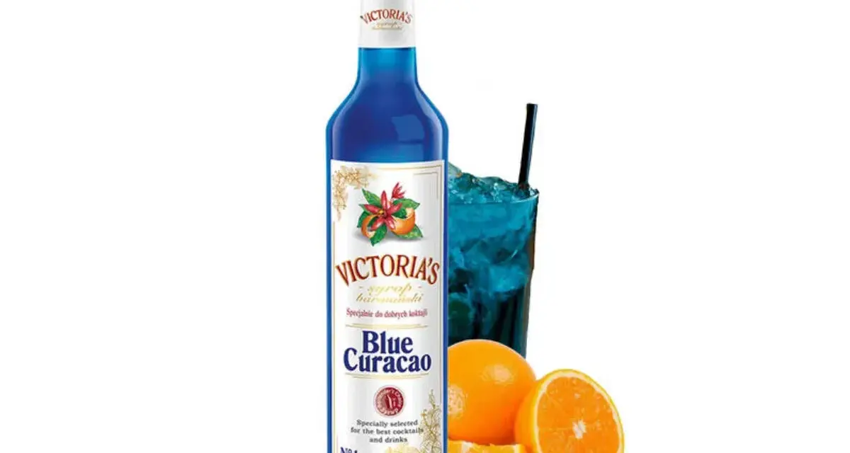 Niebieski syrop Blue Curacao Victoria's, idealny do drinków z Malibu i orzeźwiających koktajli. Obok szklanka z lodem i napojem.