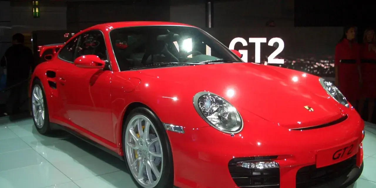 Czerwony Porsche 997 GT2 błyszczy na wystawie, gotowy do jazdy.