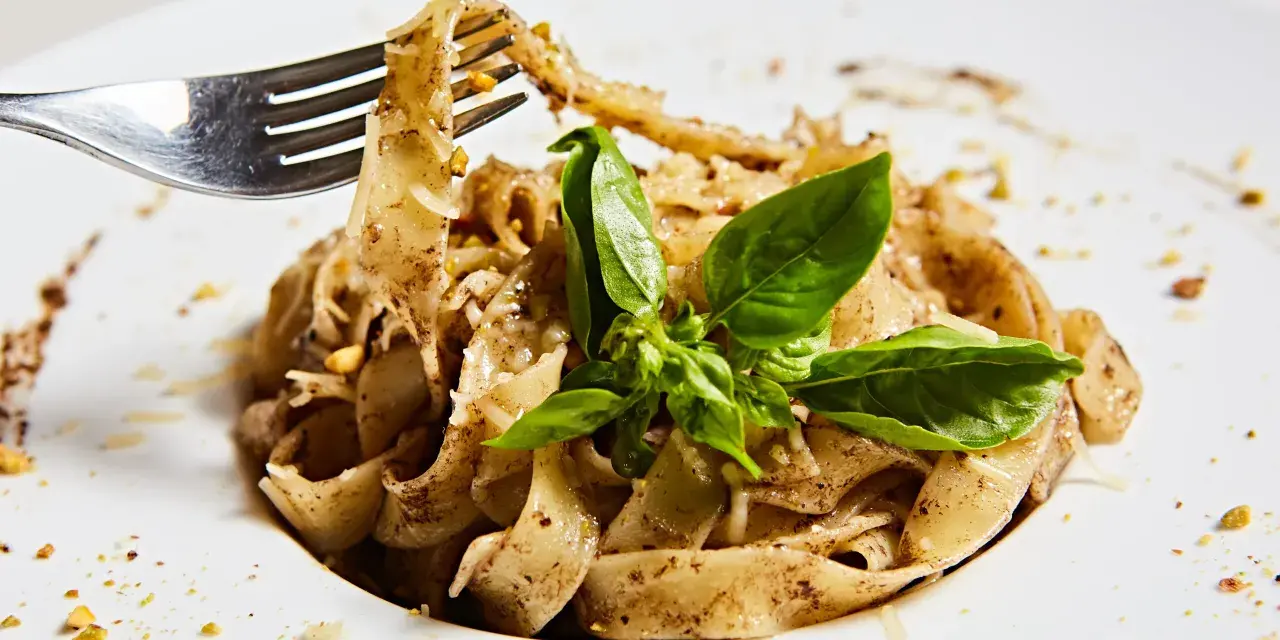 Wide tagliatelle z parmezanem i bazylią, kuszące aromatem, który zdradza, jaki smak ma trufla.
