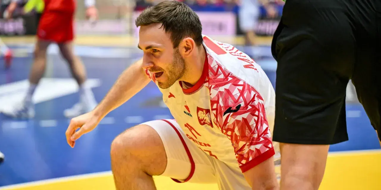 Arkadiusz Moryto w białej koszulce z czerwonymi wzorami, w akcji na boisku.