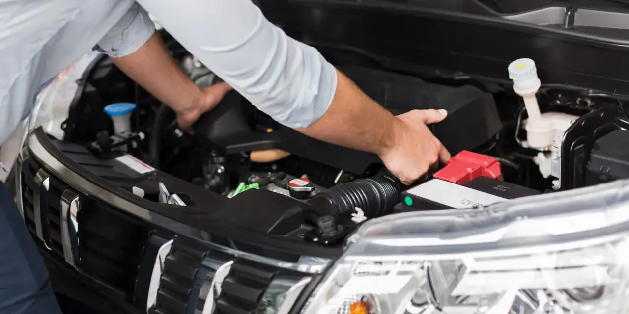 Meccanico controlla il motore per problemi al motorino d'avviamento.