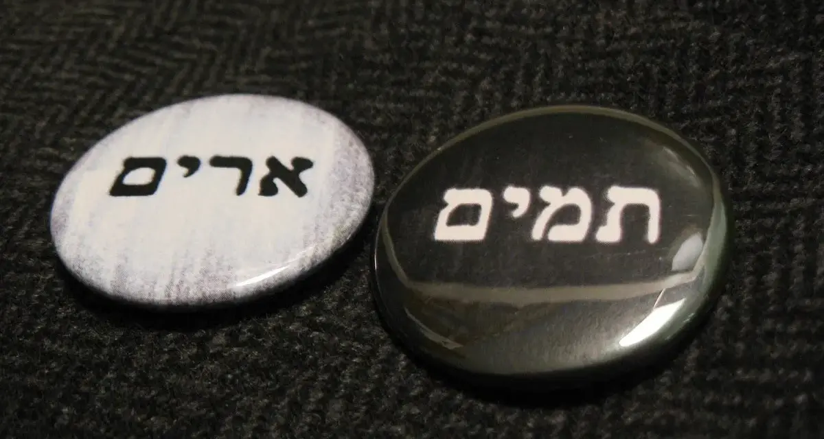 Two round pins with Hebrew text: "Urim" on a white background and "Thummim" on a black background.
