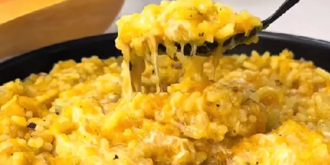 Risotto cremoso de calabaza en un plato, con una cuchara sacando una porción.