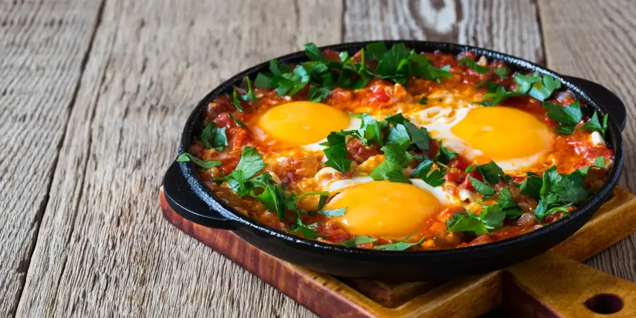 Jajka sadzone w sosie pomidorowym z natką pietruszki, idealne na śniadanie keto. Proste dieta keto przepisy.