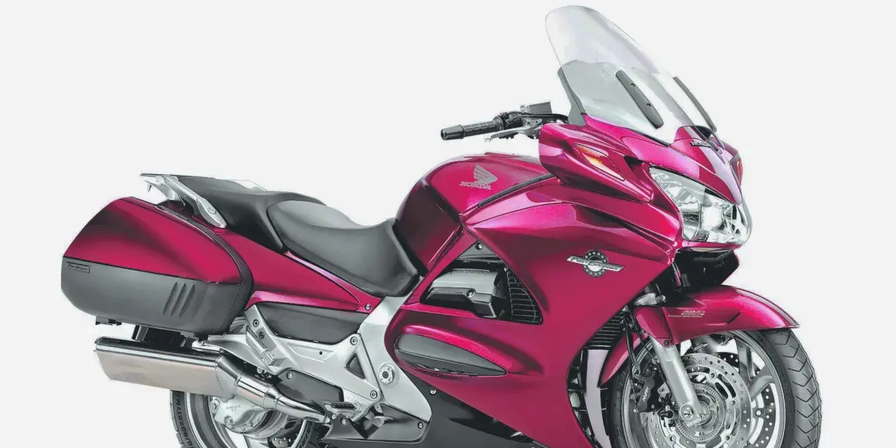 Różowy motocykl Honda ST 1300, gotowy na długie trasy, choć czasem zdarzają się mu drobne awarie.