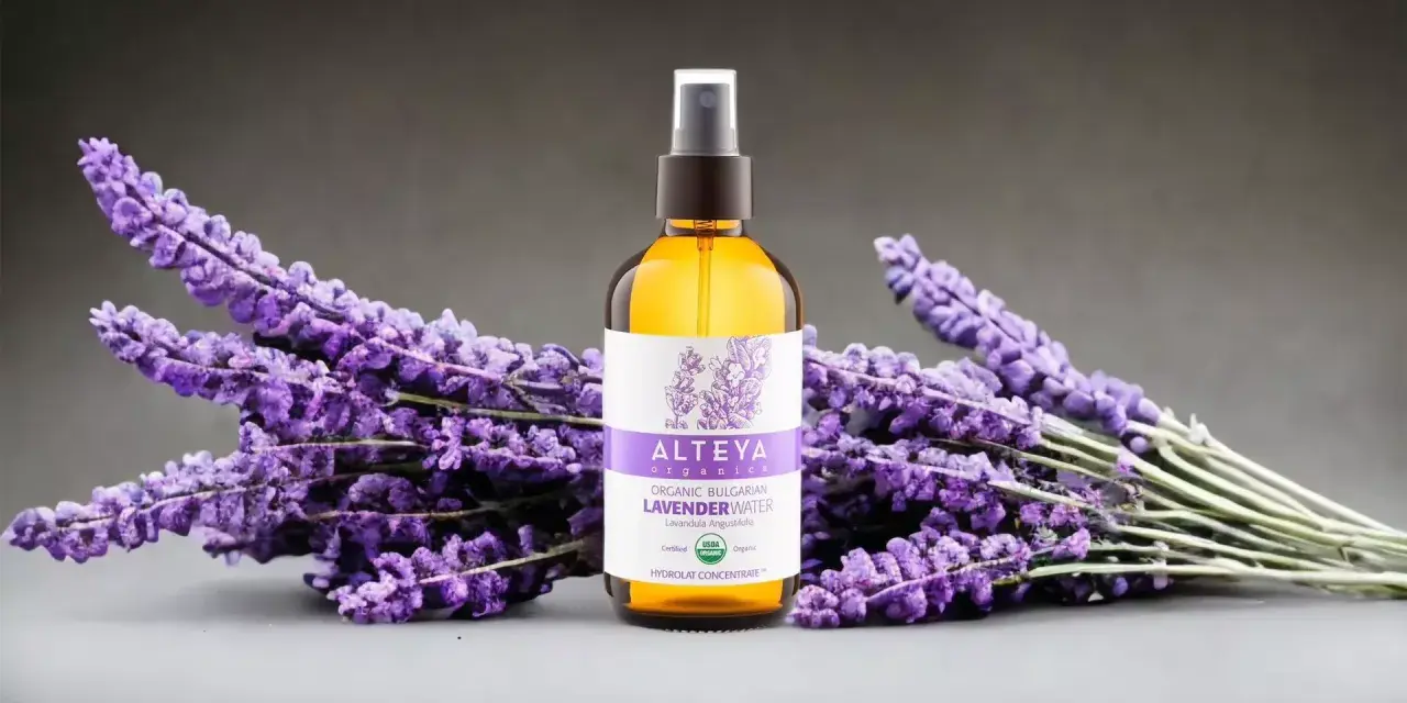 Butelka z organiczną wodą lawendową Alteya Organics otoczona bukietami fioletowej lawendy.