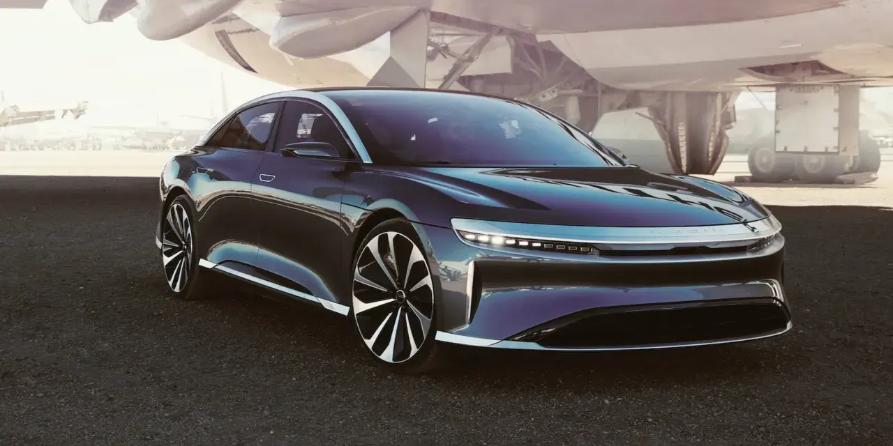 Ciemny sedan Lucid Air na tle samolotu.