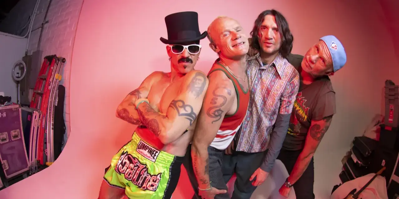 Les membres de Red Hot Chili Peppers posent ensemble, un groupe de rock iconique.