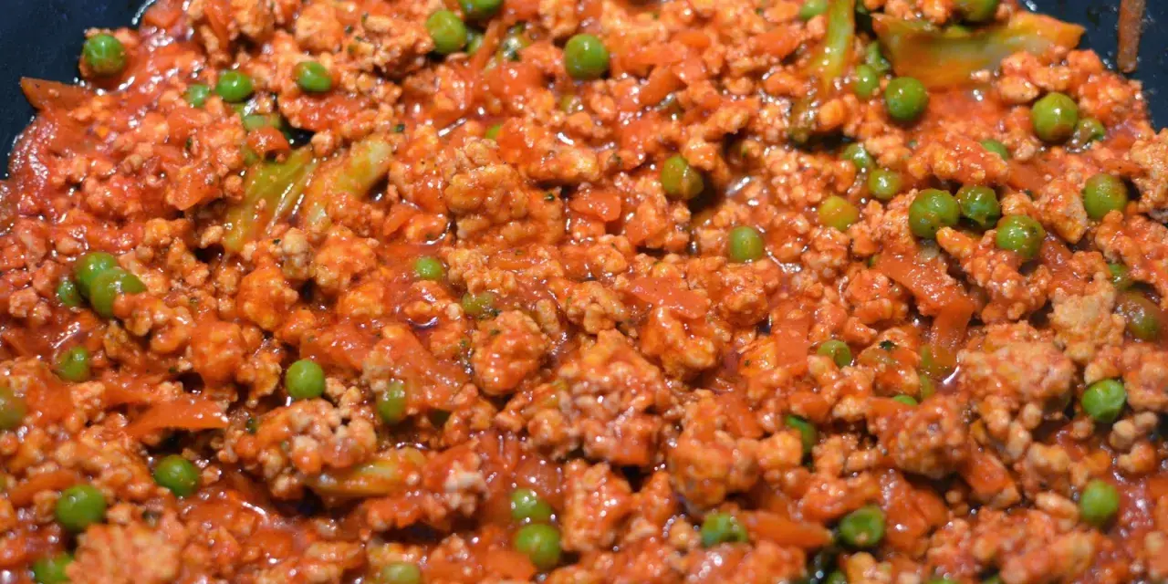 Pyszne spaghetti con piselli z mielonym mięsem i groszkiem w sosie pomidorowym.