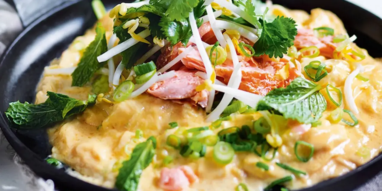 Leichte Sommergerichte: Gebratener Lachs mit cremiger Sauce, Sojasprossen, Koriander und Minze in einer Pfanne.