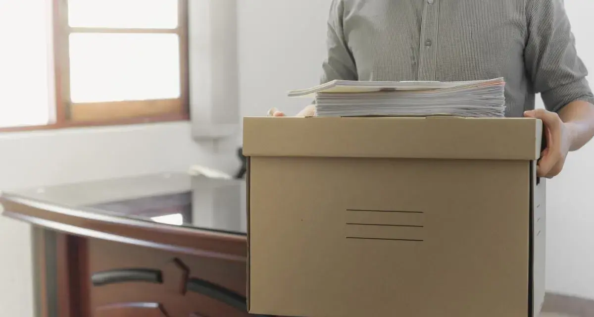 Hombre con caja de cartón y papeles, listo para irse. ¿Los 15 días de preaviso son naturales o laborales?