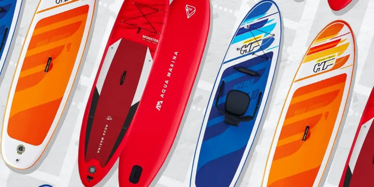 Bunte SUP-Boards, auch Stand-Up-Paddleboards genannt, liegen nebeneinander. Sie sind für Wassersportler gedacht.