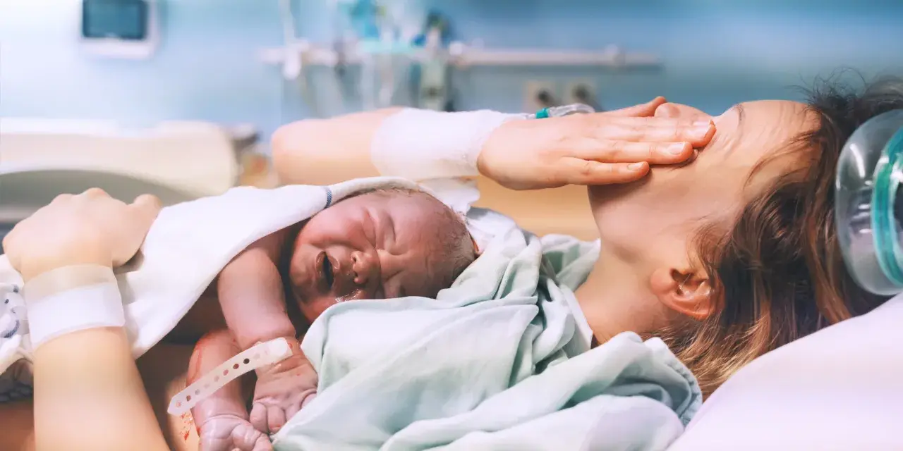 Nowy człowiek na świecie! Po długim porodzie, wyczerpana mama tuli swoje maleństwo.