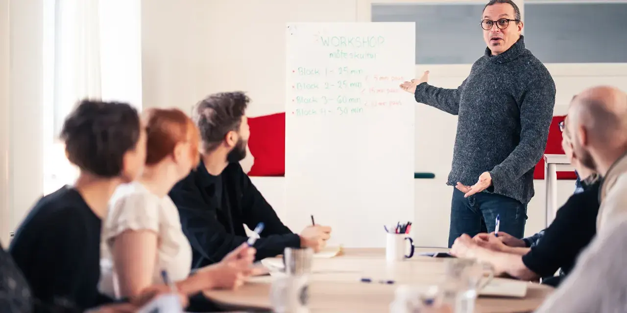 Man leder en workshop om möteskultur, där deltagarna fokuserar på kompetens utveckling.