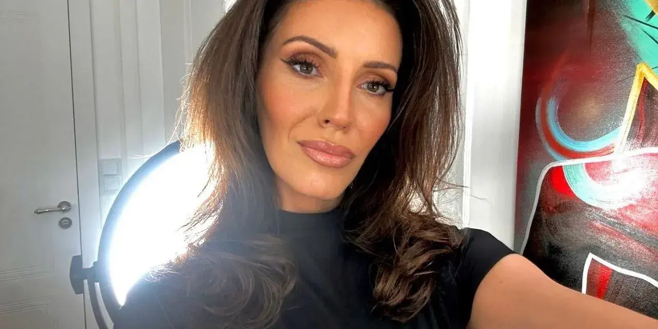 Dominika Serowska, wiek nieznany, pozuje do selfie w czarnej bluzce. W tle widać drzwi, lampę i abstrakcyjny obraz.