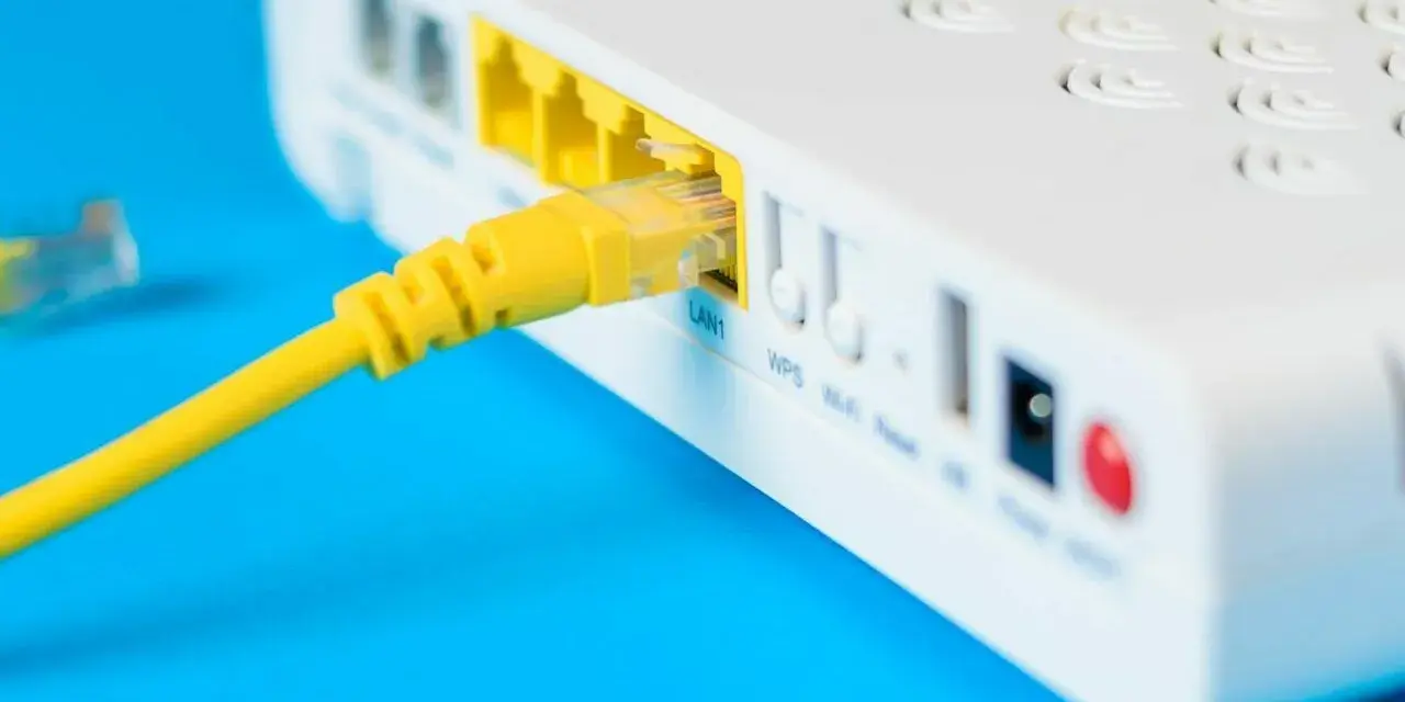 Żółty kabel sieciowy podłączony do portu LAN routera i modemu.